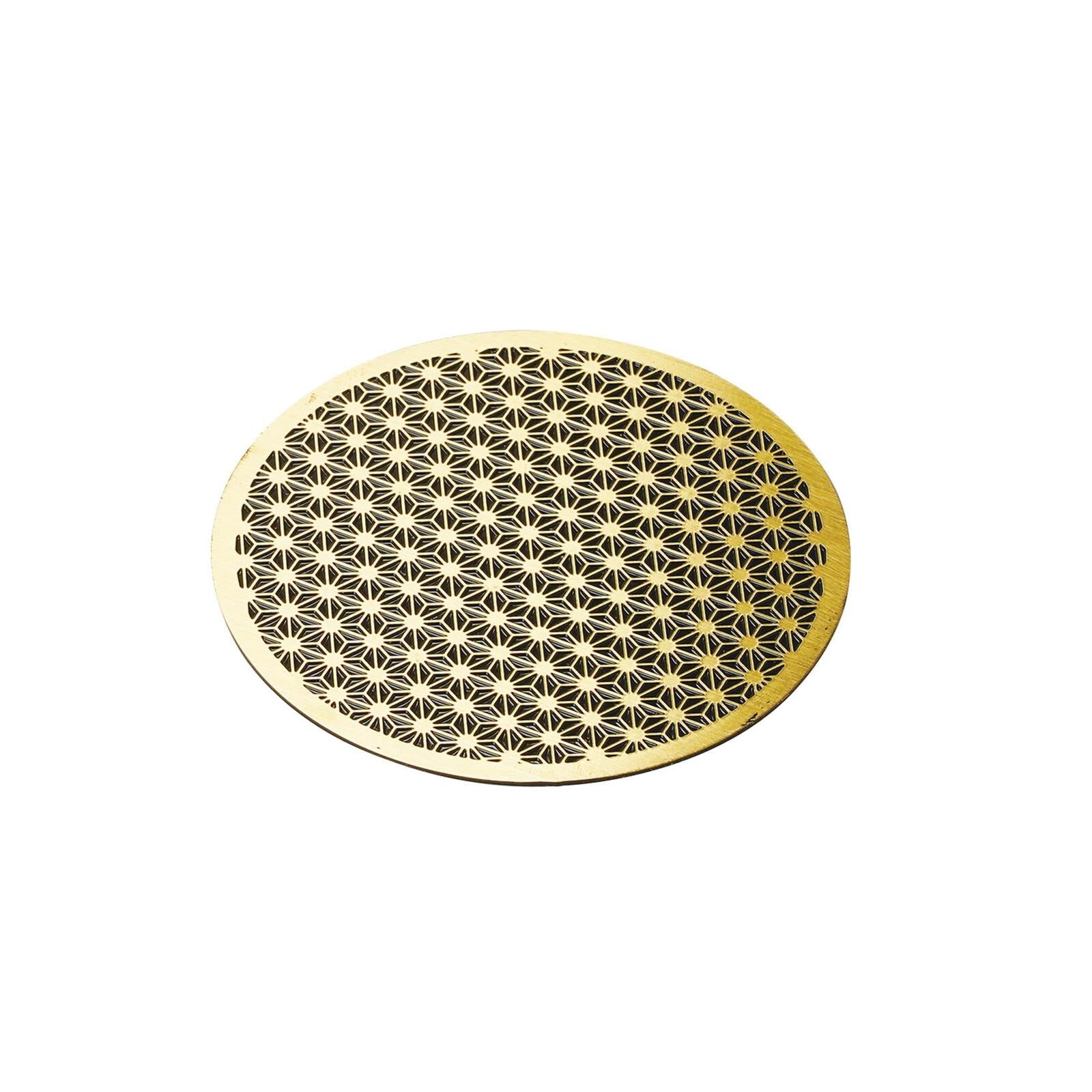 Solid brass coaster with intricate Japanese Asanoha hemp leaf pattern on a dark wooden surface