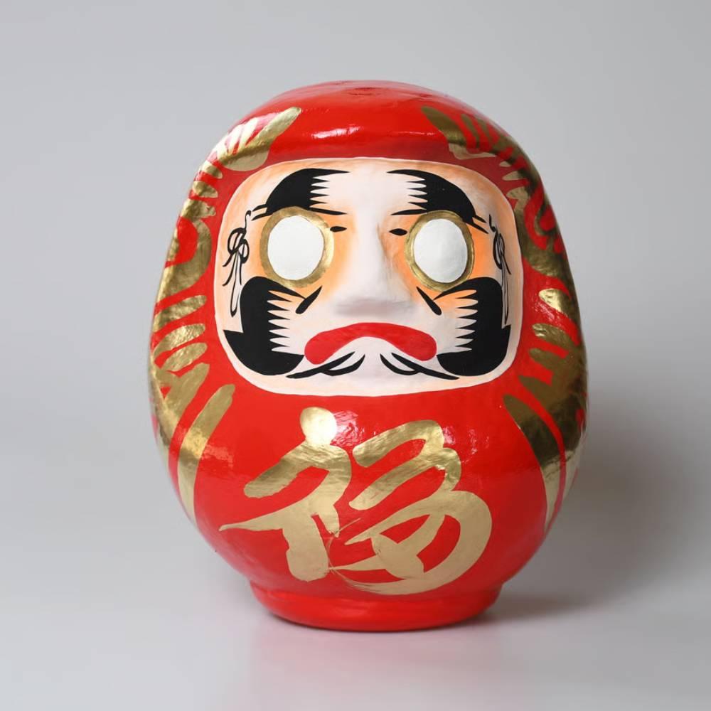 A 25cm traditional red Shirakawa Daruma doll with crane-shaped eyebrows and turtle-shaped whiskers on a white background