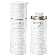 Kose DECORTE AQ Absolute Emulsion Micro Radiance bottle on a reflective surface, showcasing its luxurious packaging and texture.