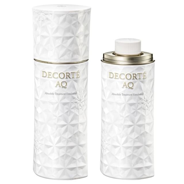 Kose DECORTE AQ Absolute Emulsion Micro Radiance bottle on a reflective surface, showcasing its luxurious packaging and texture.