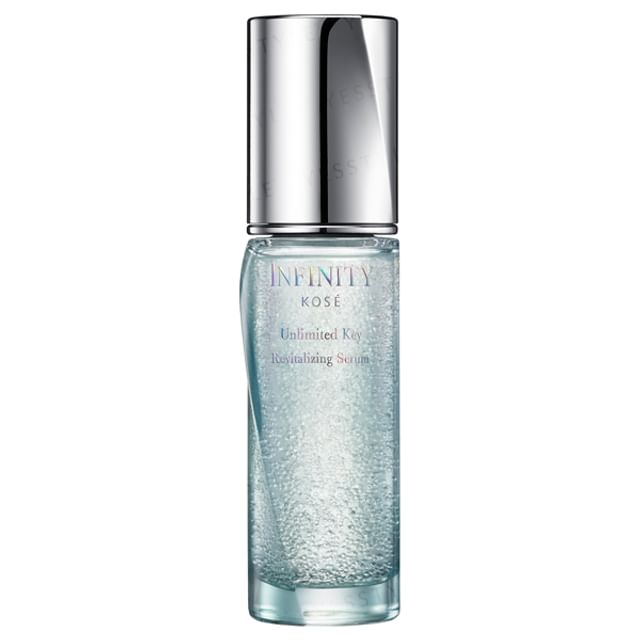Kose INFINITY Unlimited Key Revitalizing Serum bottle on a reflective surface, showcasing its luxurious packaging and highlighting its revitalizing benefits for youthful skin.