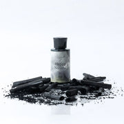 Happy Natural Bio Activated Hemp Charcoal Powder in a glass jar with a scoop, showcasing its dark color and texture.