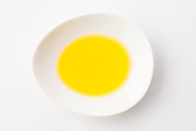 Golden egoma oil in a white dish
